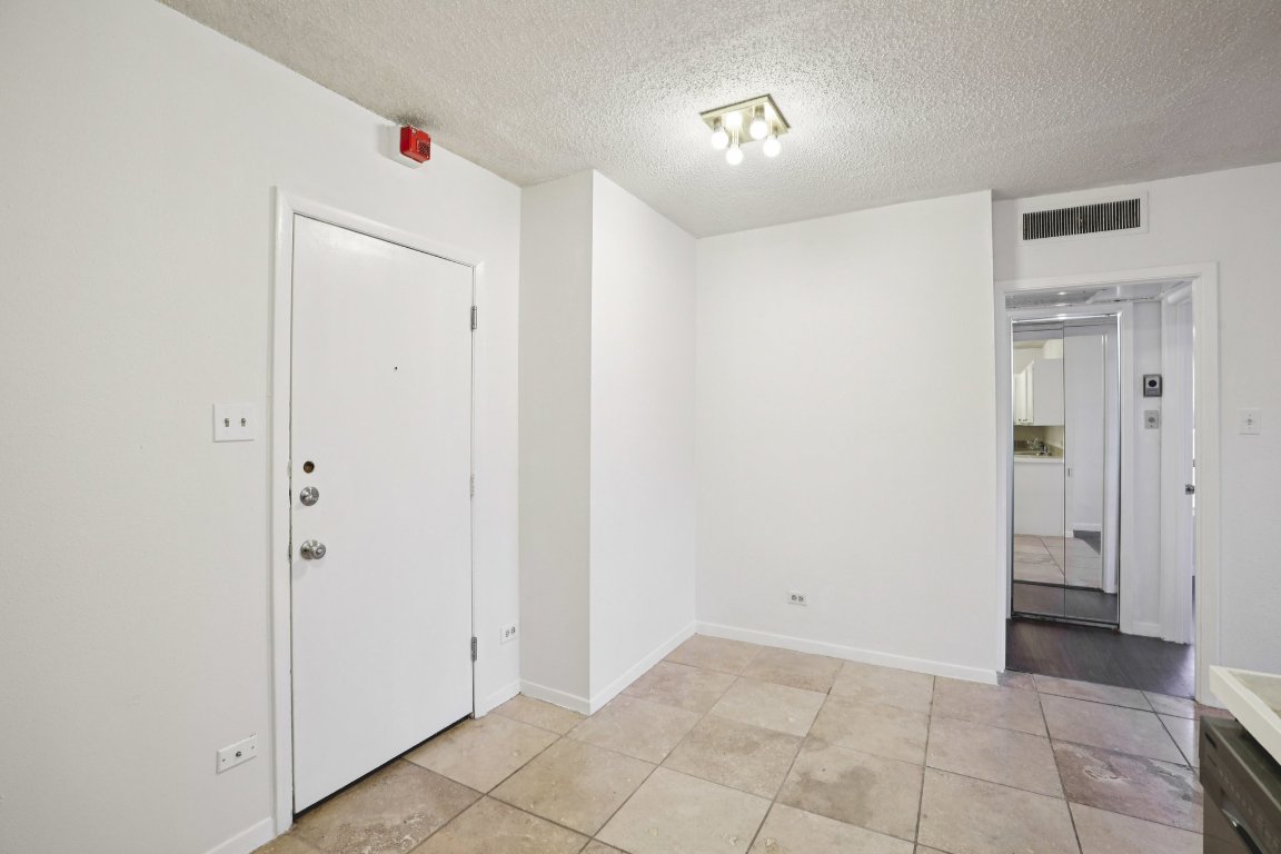1212 Guadalupe Street, Unit 210 Austin, TX 78701 - Photo 9 of 12 Foyer featuring a textured ceiling and light tile patterned flooring