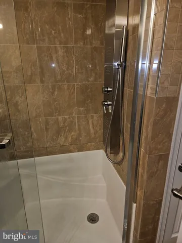 a bathroom with a granite countertop sink and a shower