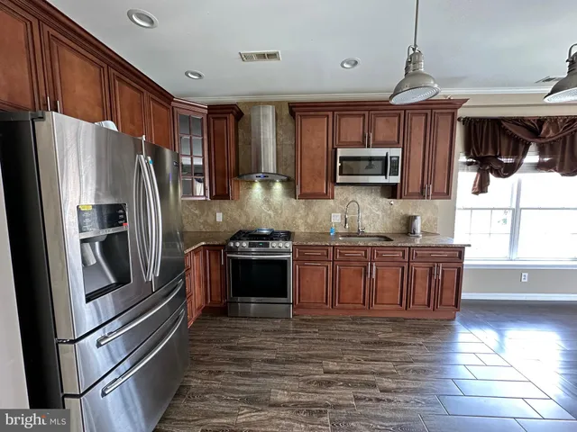 a kitchen with granite countertop a refrigerator stove top oven and sink
