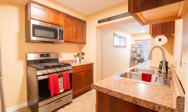 a kitchen with stainless steel appliances granite countertop a stove and a microwave