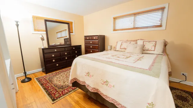 a bedroom with a bed and wooden floor