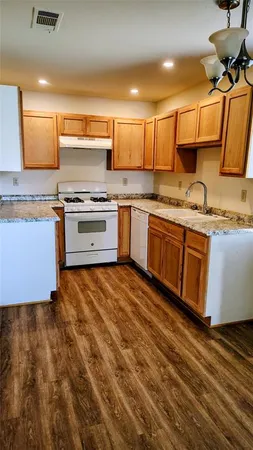 a large kitchen with stainless steel appliances granite countertop a stove and a sink