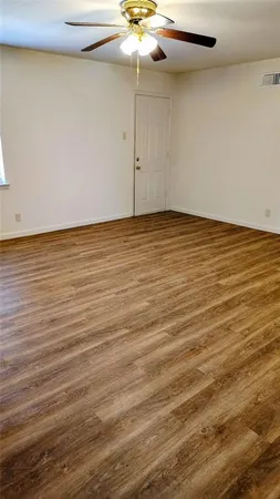 a view of an empty room with a chandelier fan