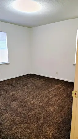 an empty room with wooden floor and cabinet