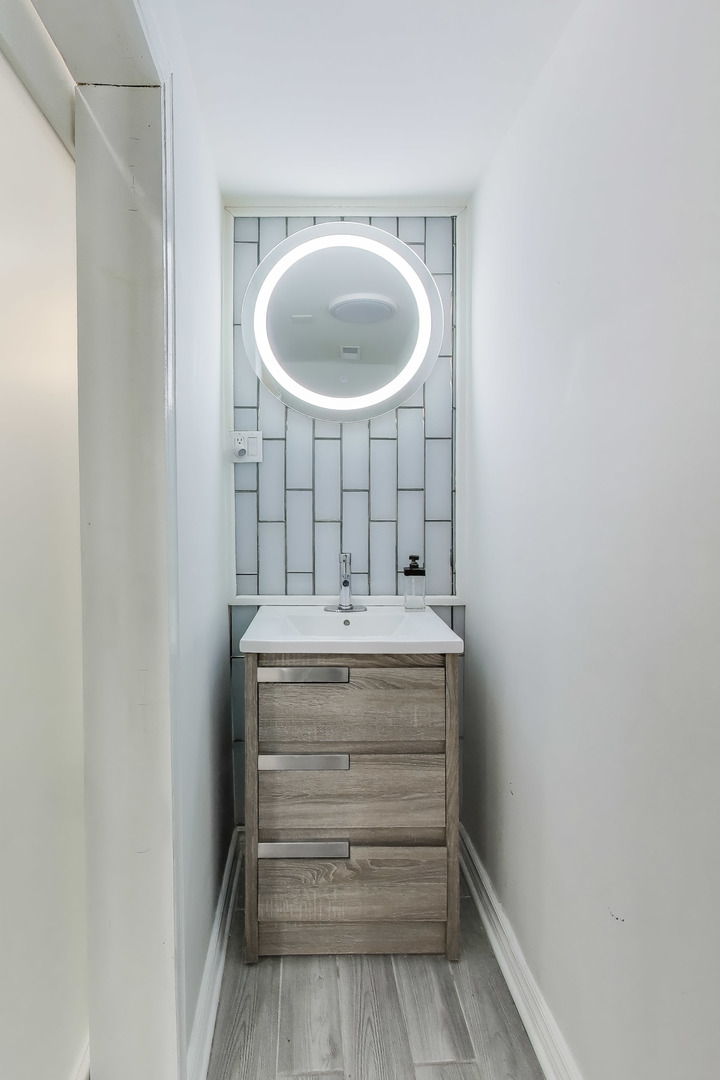 4049 South Indiana Avenue Chicago, IL 60653 - Photo 12 of 23 a bathroom with a sink and a mirror