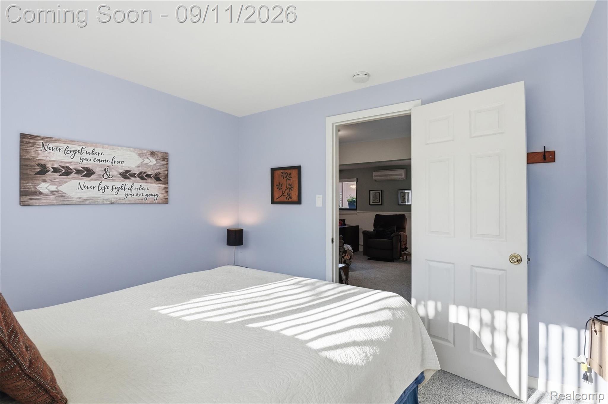 16799 Farmington Road Livonia, MI 48154 - Photo 38 of 71 Light blue painted walls with white trim, white paneled door with brass hardware, and light-colored carpet flooring