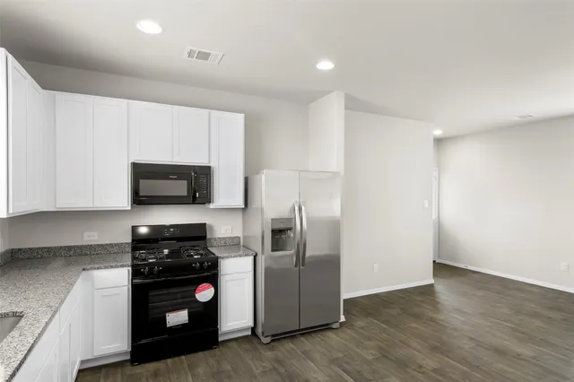a kitchen with stainless steel appliances granite countertop a sink and a stove