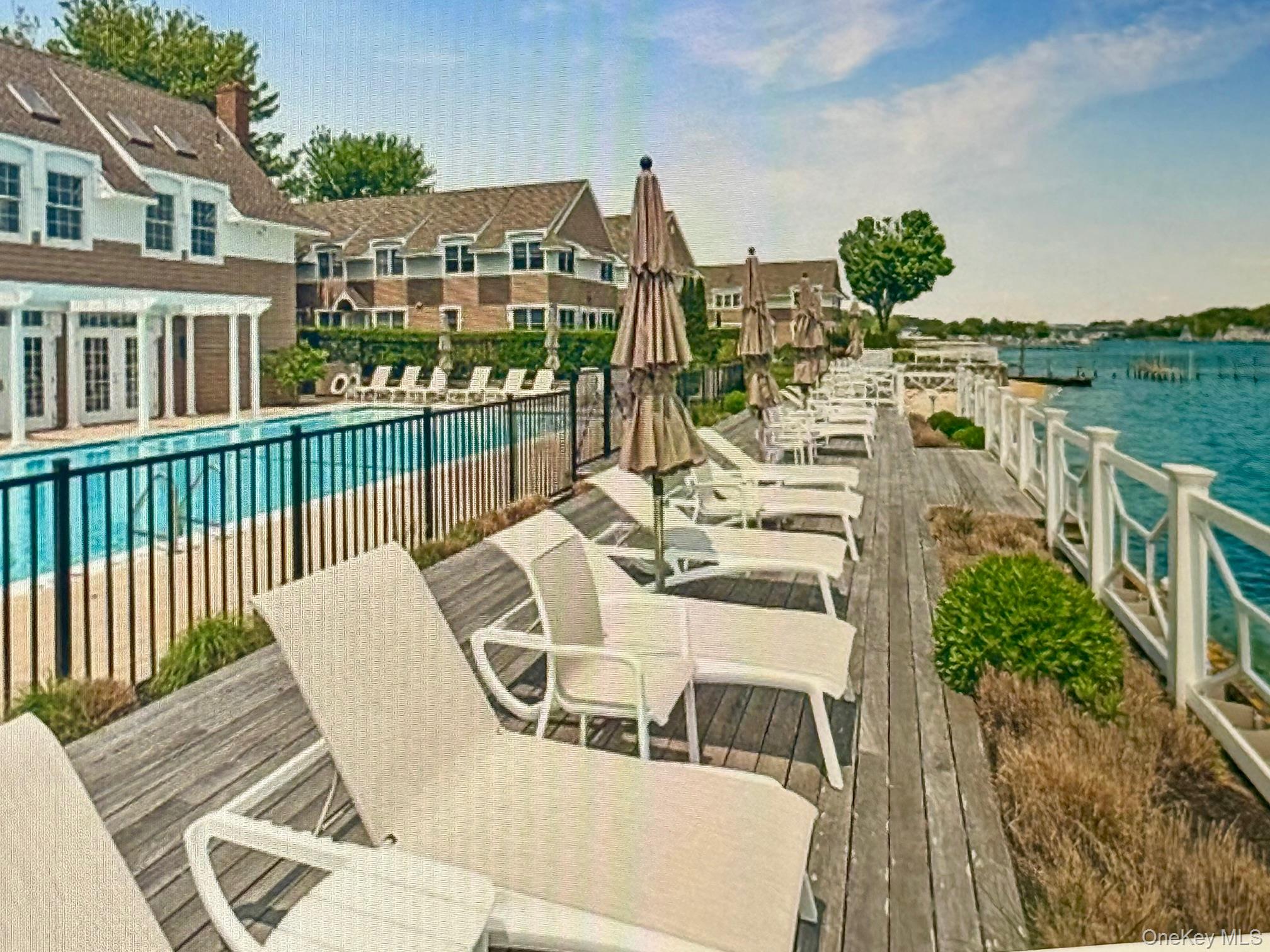 49 Canoe Place Road, Unit 212 Hampton Bays, NY 11946 - Photo 12 of 22 a view of a balcony with chairs and a table