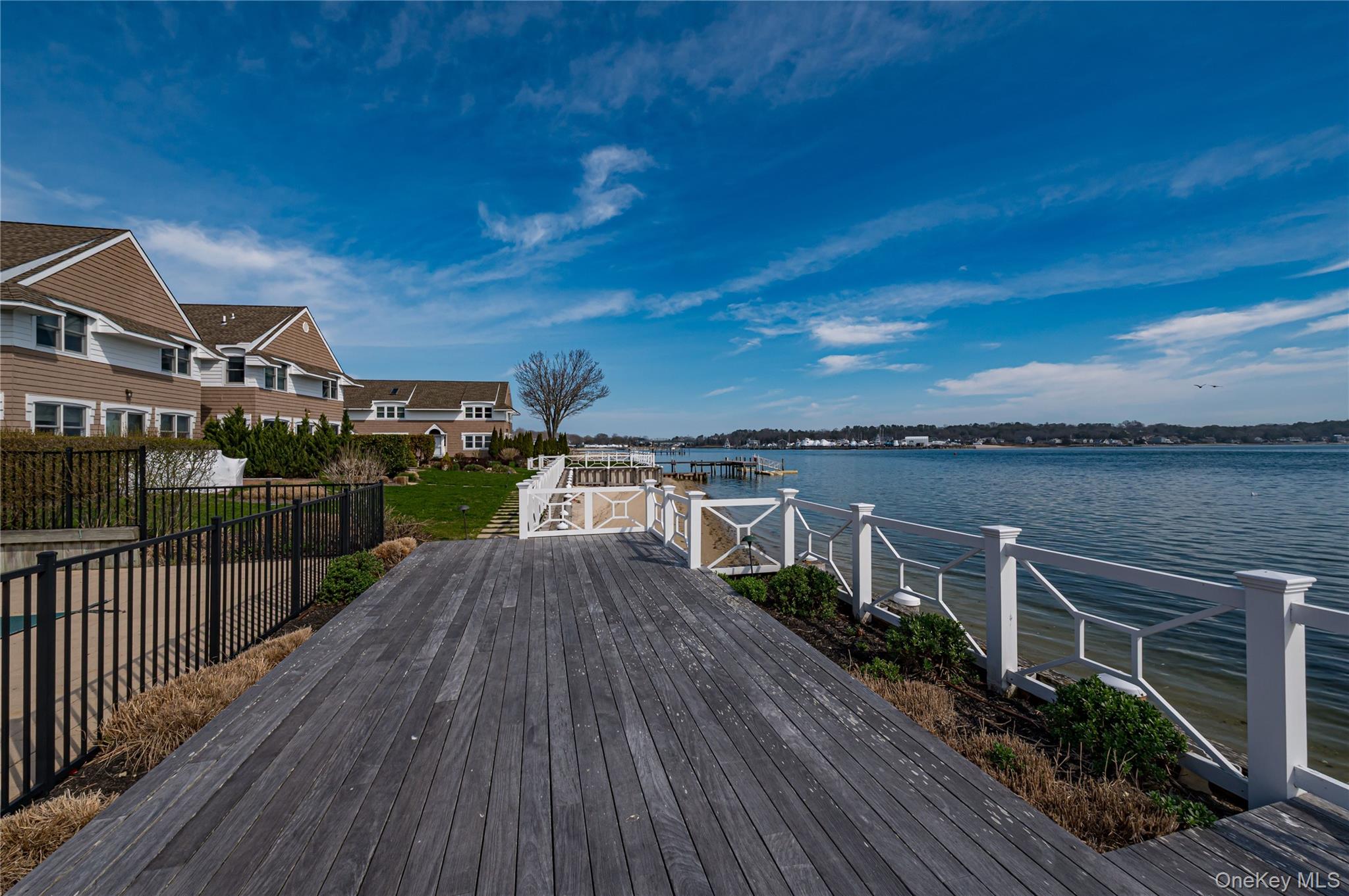 49 Canoe Place Road, Unit 212 Hampton Bays, NY 11946 - Photo 19 of 22 a view of a house with wooden deck