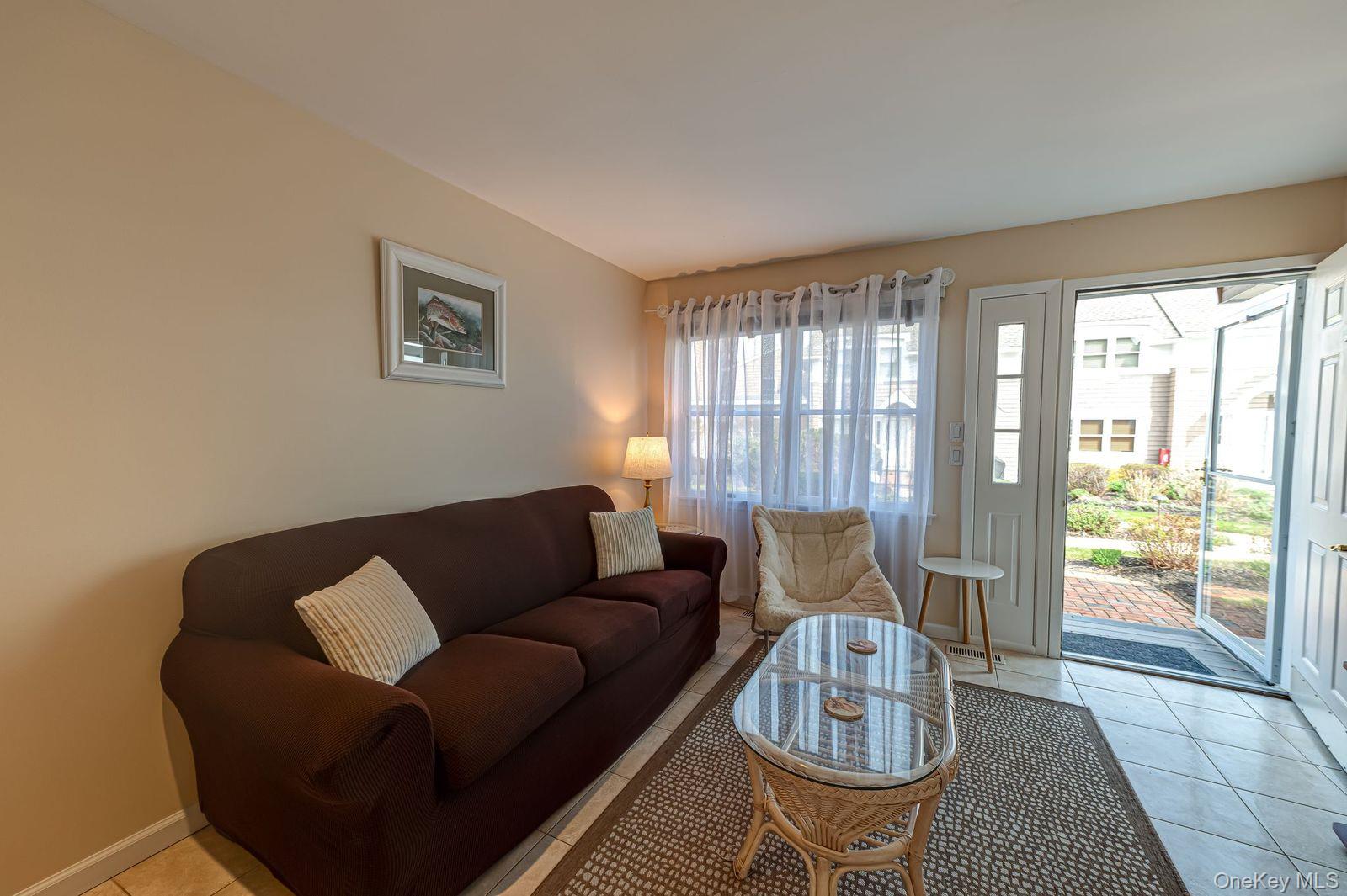 49 Canoe Place Road, Unit 212 Hampton Bays, NY 11946 - Photo 4 of 22 a living room with furniture and a floor to ceiling window