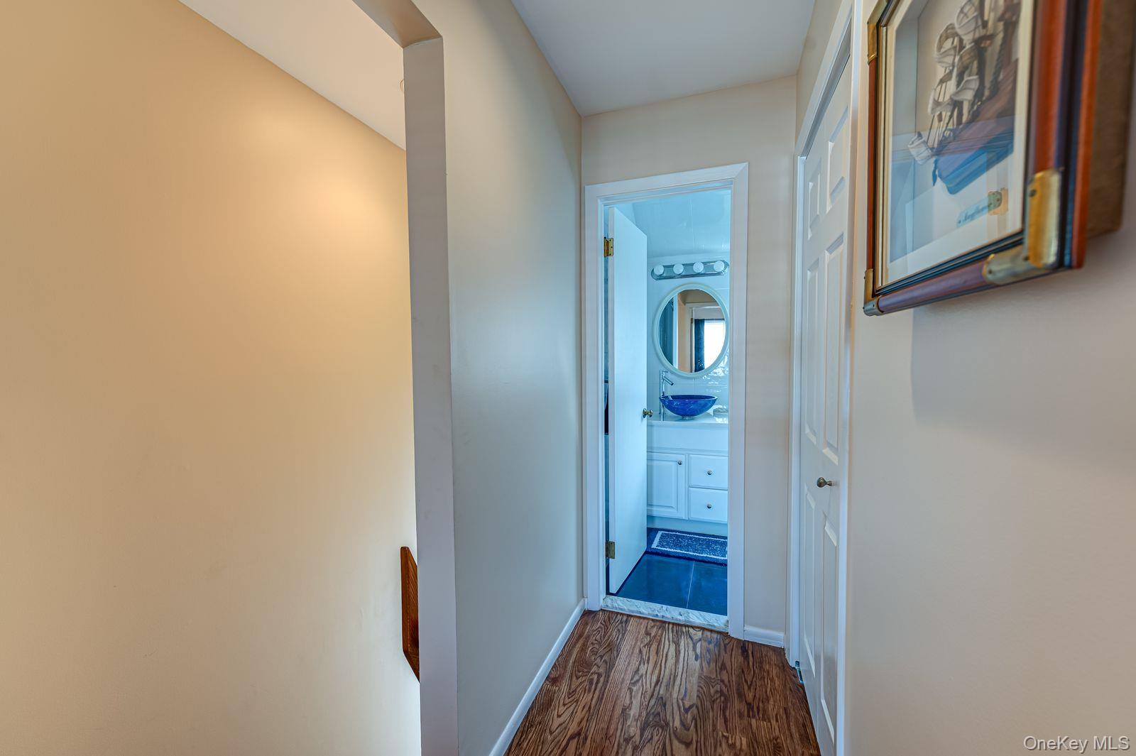 49 Canoe Place Road, Unit 212 Hampton Bays, NY 11946 - Photo 10 of 22 a view of a hallway with wooden floor and closet