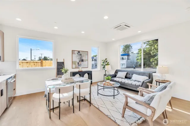 a kitchen with stainless steel appliances granite countertop a stove a sink dishwasher a dining table and chairs with wooden floor