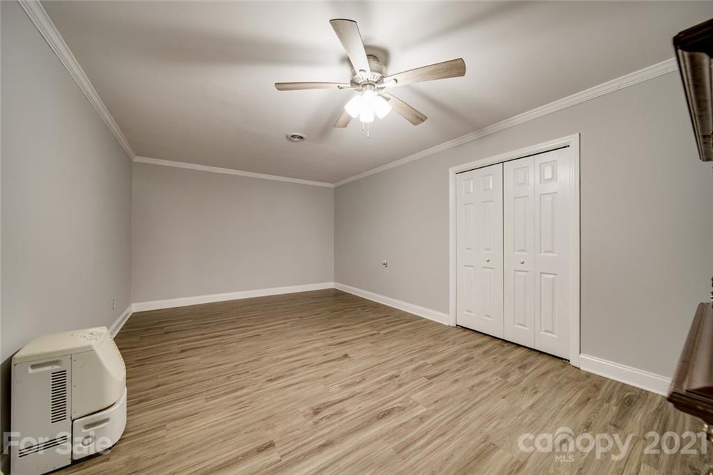 6460 Talley Road Stanfield, NC 28163 - Photo 20 of 47 an empty room with wooden floor fan and windows