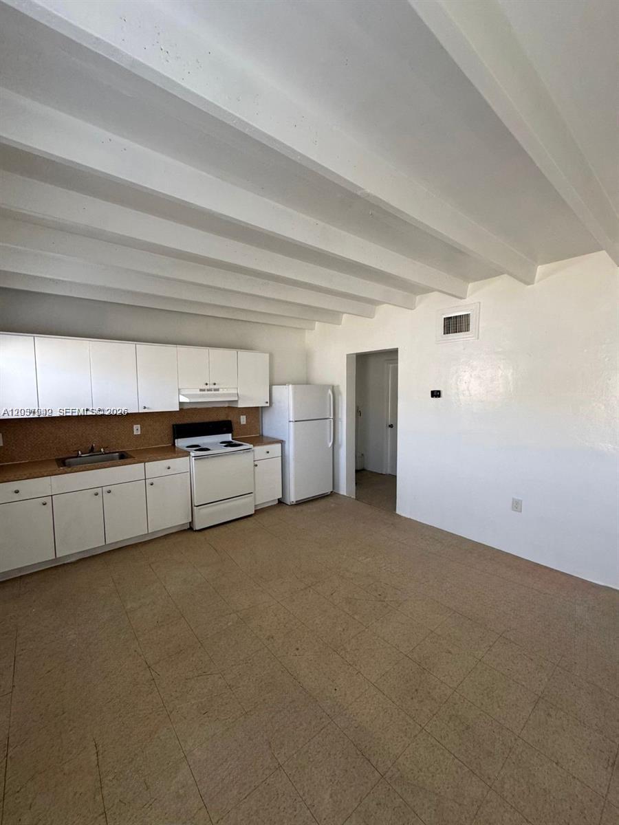 320 Southwest 11th Avenue, Unit 2 Homestead, FL 33030 - Photo 3 of 11 a view of a kitchen with furniture and cabinets