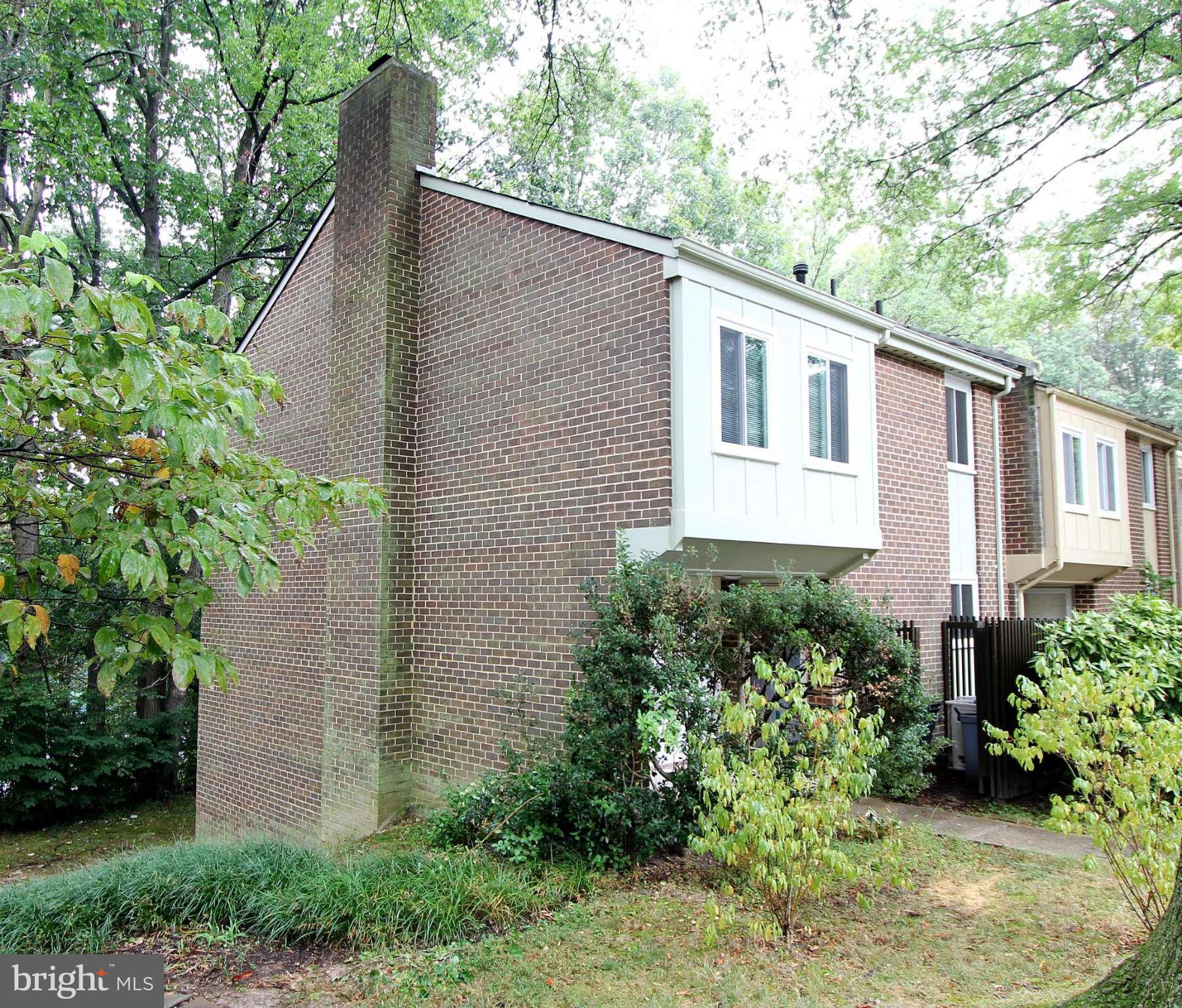 11051 Saffold Way Reston, VA 20190 - Photo 2 of 18 a backyard of a house with plants and large tree