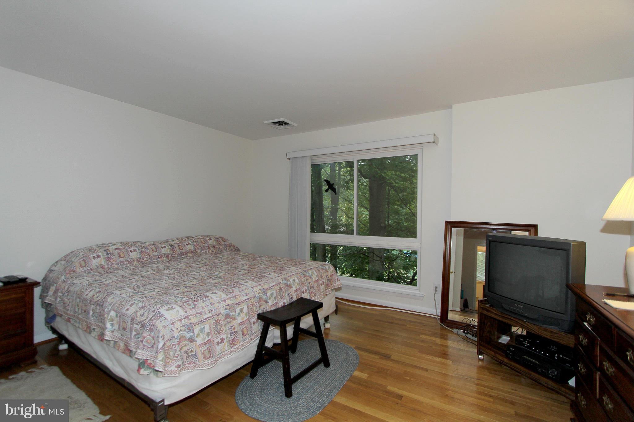 11051 Saffold Way Reston, VA 20190 - Photo 14 of 18 a bedroom with a bed and a flat screen tv