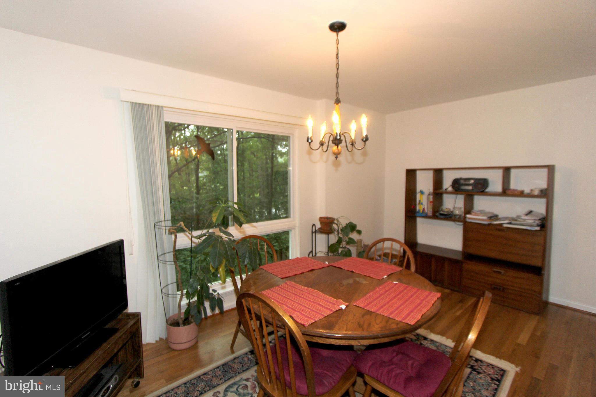 11051 Saffold Way Reston, VA 20190 - Photo 7 of 18 a view of a dining room with furniture window and wooden floor