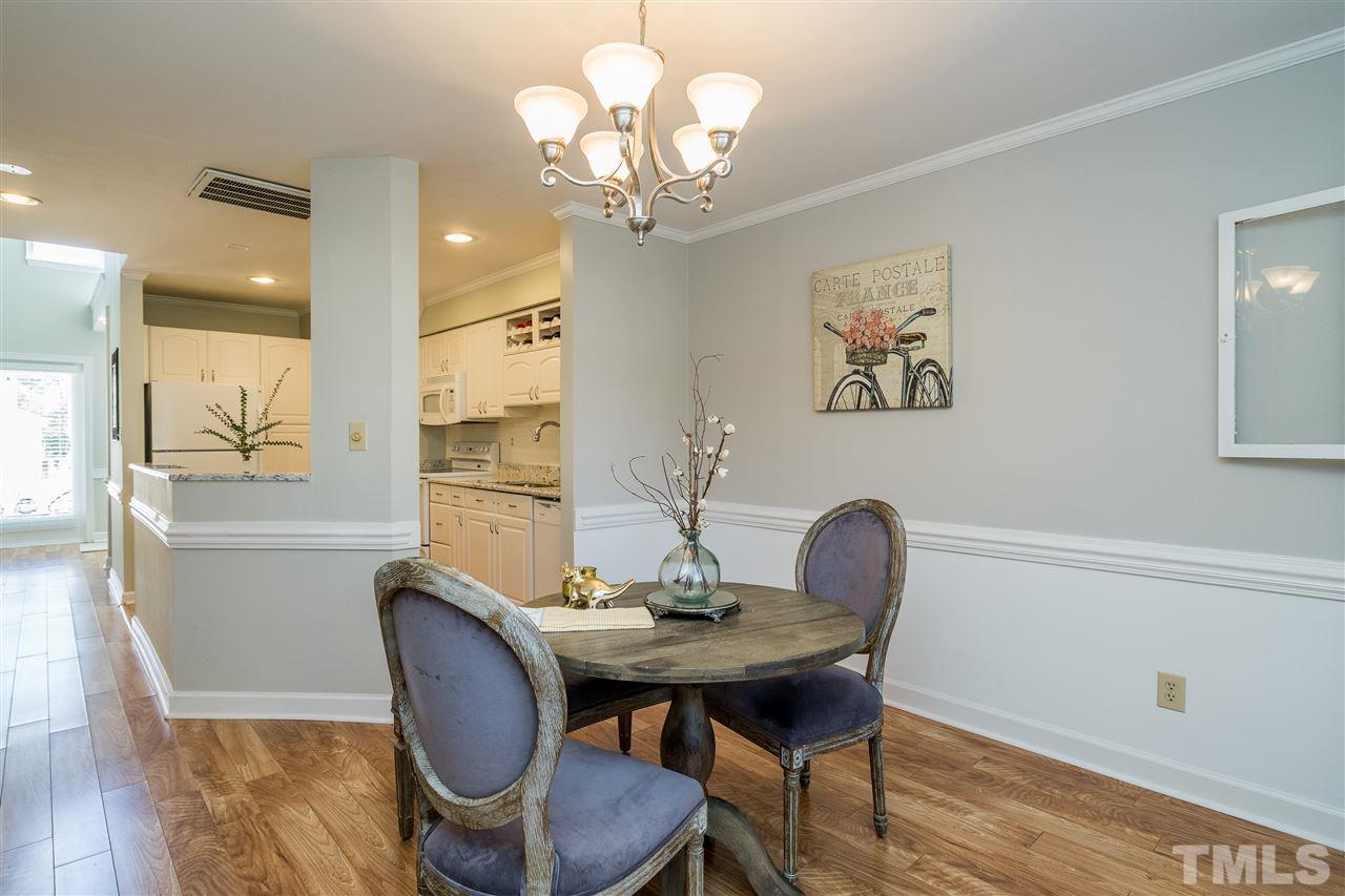 7010 Sandy Forks Road, Unit 207 Raleigh, NC 27615 - Photo 12 of 27 a view of a dining room with furniture wooden floor and a chandelier