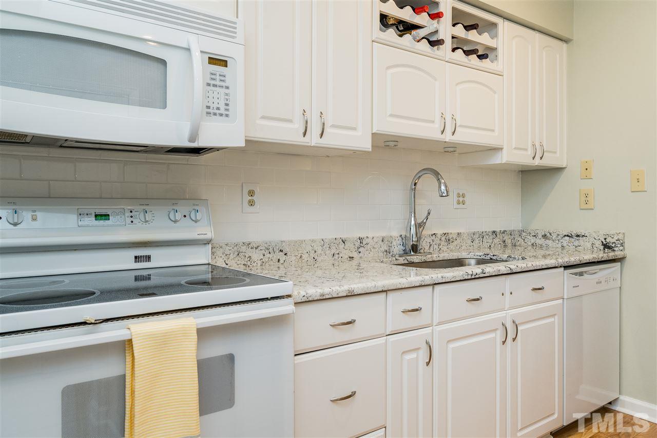 7010 Sandy Forks Road, Unit 207 Raleigh, NC 27615 - Photo 14 of 27 a kitchen with granite countertop white cabinets and a sink