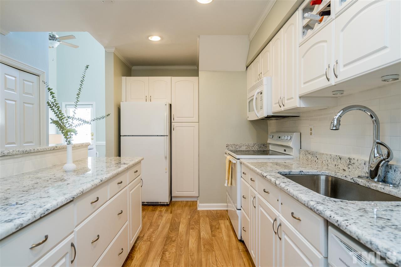 7010 Sandy Forks Road, Unit 207 Raleigh, NC 27615 - Photo 16 of 27 a kitchen with stainless steel appliances granite countertop a sink stove and refrigerator