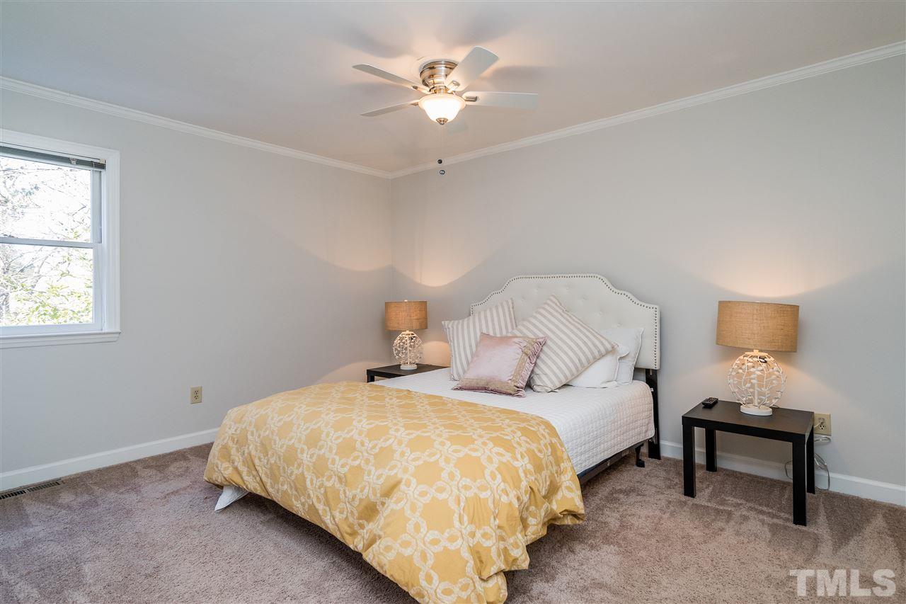 7010 Sandy Forks Road, Unit 207 Raleigh, NC 27615 - Photo 20 of 27 a bedroom with bed and a chandelier