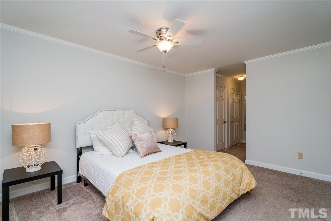 7010 Sandy Forks Road, Unit 207 Raleigh, NC 27615 - Photo 21 of 27 a bedroom with a bed and a chandelier