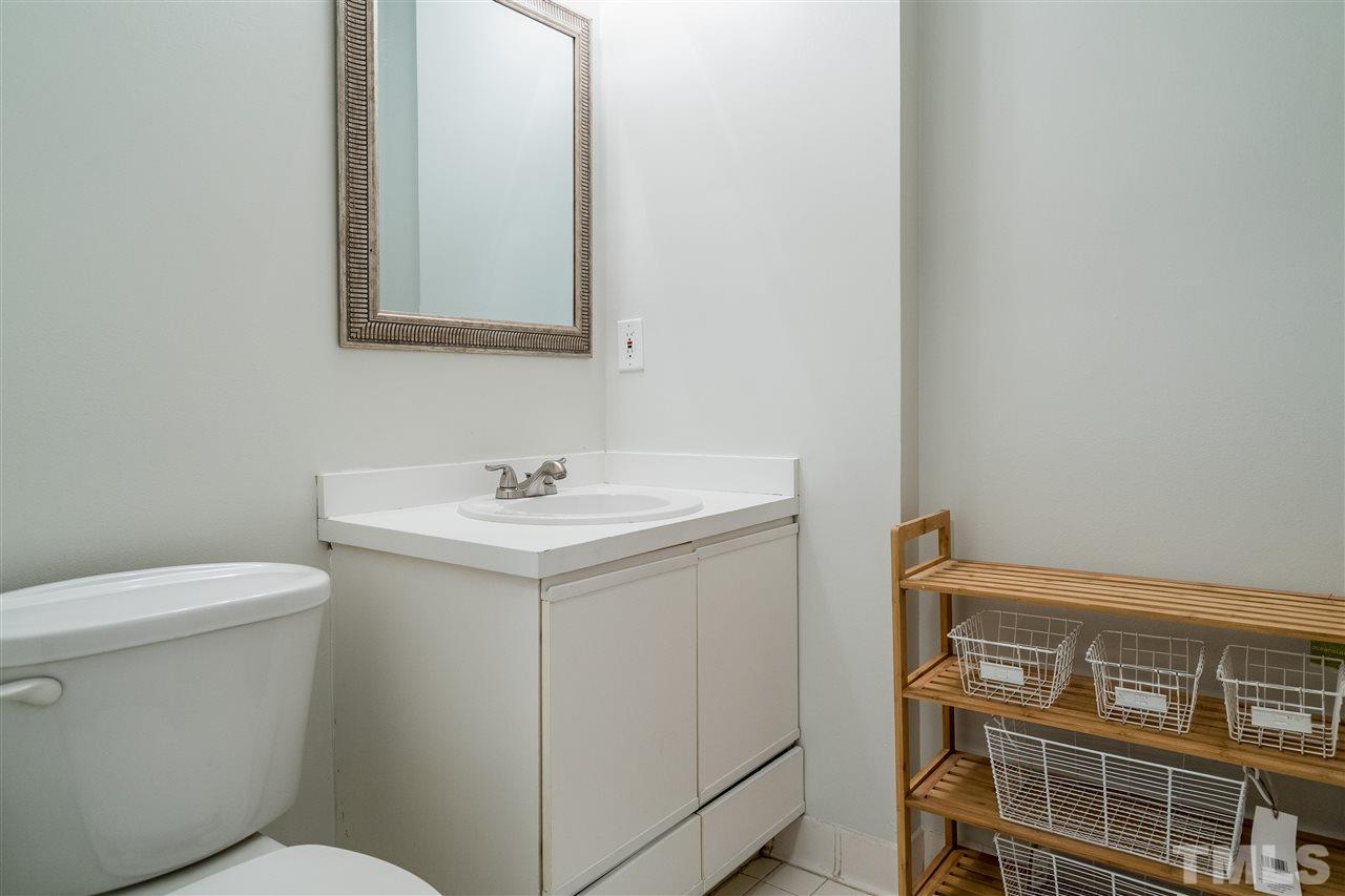 7010 Sandy Forks Road, Unit 207 Raleigh, NC 27615 - Photo 23 of 27 a bathroom with a sink toilet and mirror