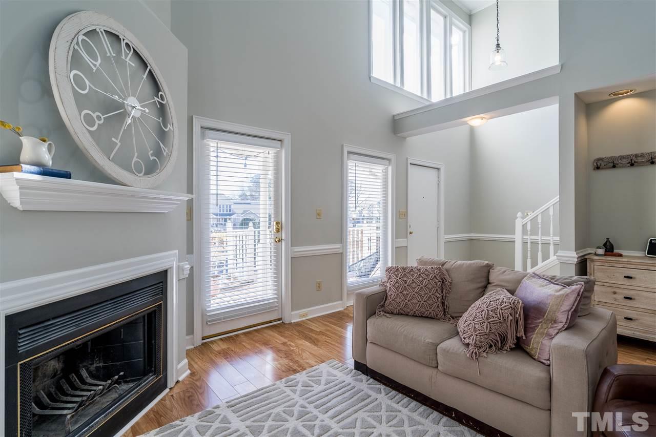 7010 Sandy Forks Road, Unit 207 Raleigh, NC 27615 - Photo 6 of 27 a living room with furniture a fireplace and a large window