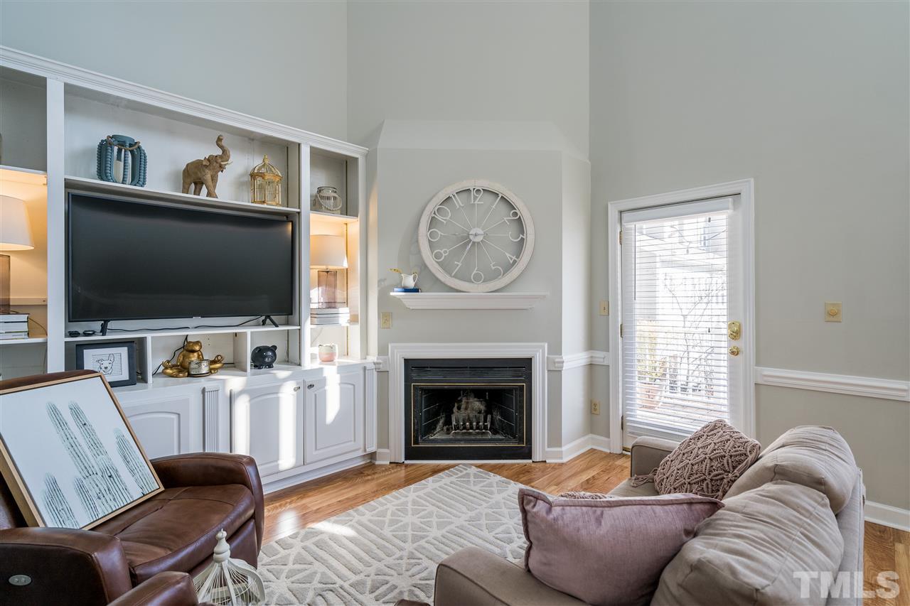 7010 Sandy Forks Road, Unit 207 Raleigh, NC 27615 - Photo 7 of 27 a living room with furniture a flat screen tv and a fireplace