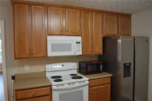 a view of kitchen with refrigerator stove and microwave
