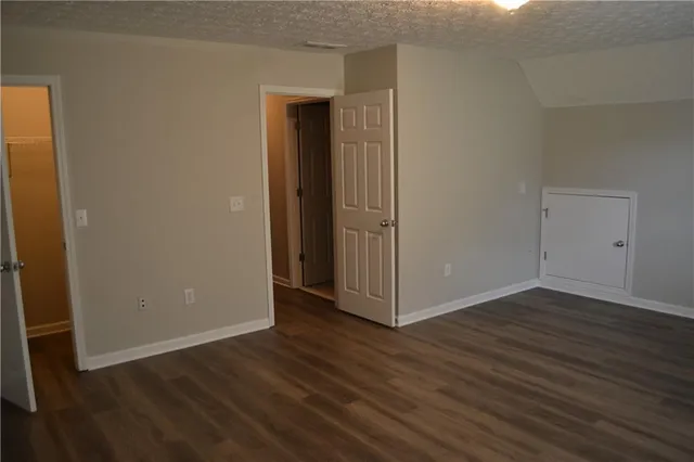 an empty room with wooden floor and closet