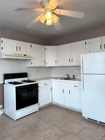 a kitchen with cabinets stainless steel appliances and a window
