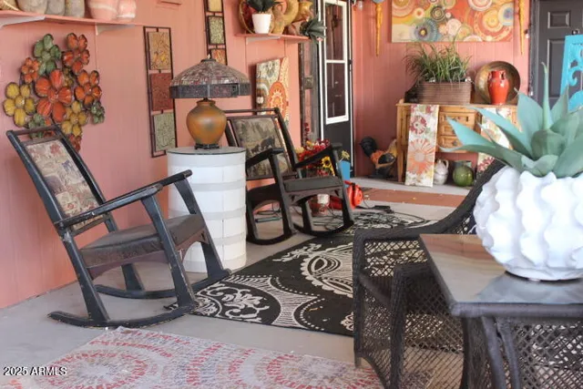 a table with chairs and a vase of flowers