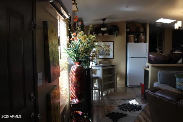 a vase of flowers sitting on a floor in front of a house