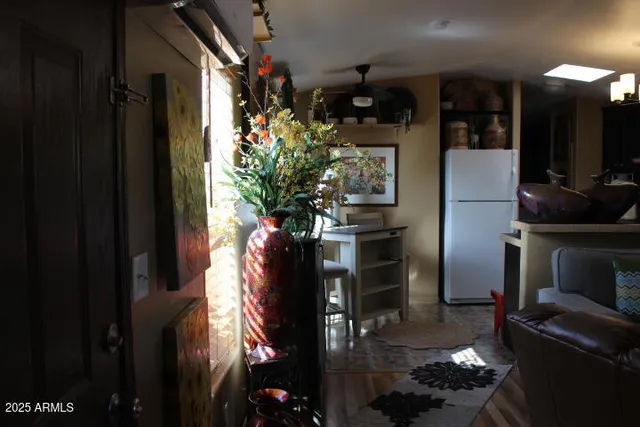 a vase of flowers sitting on a floor in front of a house