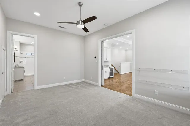 a view of a hallway with wooden floor and a kitchen