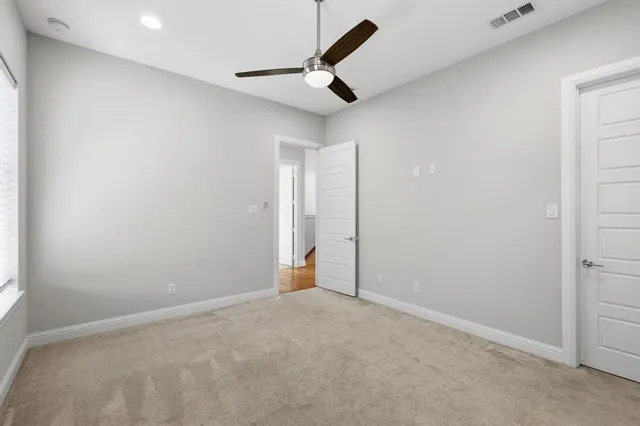 an empty room with closet and a ceiling fan