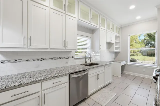 a kitchen with granite countertop white cabinets white appliances and a sink