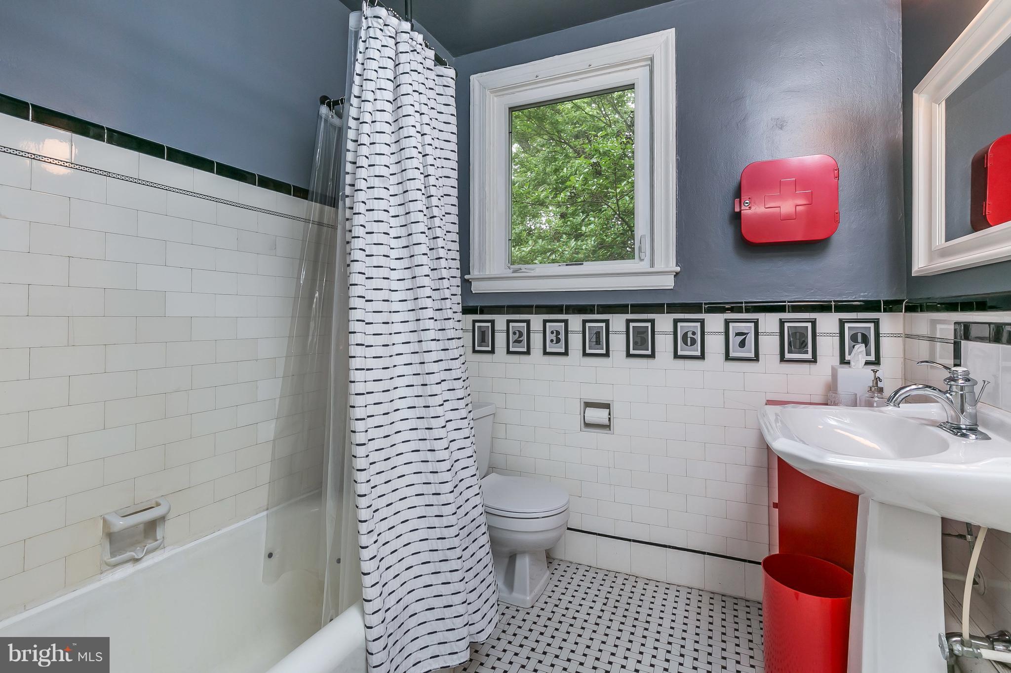 3622 Kimble Road Baltimore, MD 21218 - Photo 22 of 30 a bathroom with a sink a toilet and shower curtain