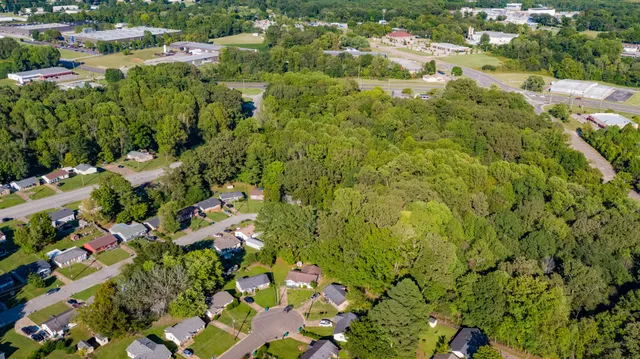 an aerial view of residential houses with outdoor space and trees