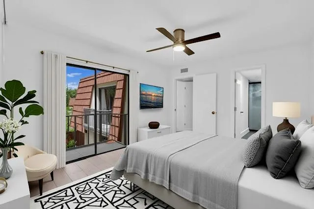 a bedroom with a large bed and a potted plant