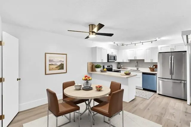 a kitchen with stainless steel appliances a dining table and chairs
