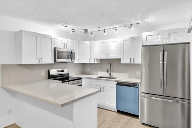 3305 Spanish Wells Drive, Unit 41B Delray Beach, FL 33445 - Photo 9 of 13 a kitchen with stainless steel appliances a refrigerator stove microwave and sink