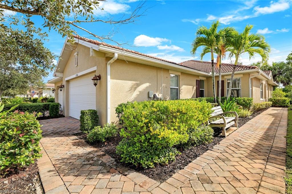 13366 Kent Street Naples, FL 34109 - Photo 1 of 23 View of front of house featuring stucco siding, a tile roof, and a garage