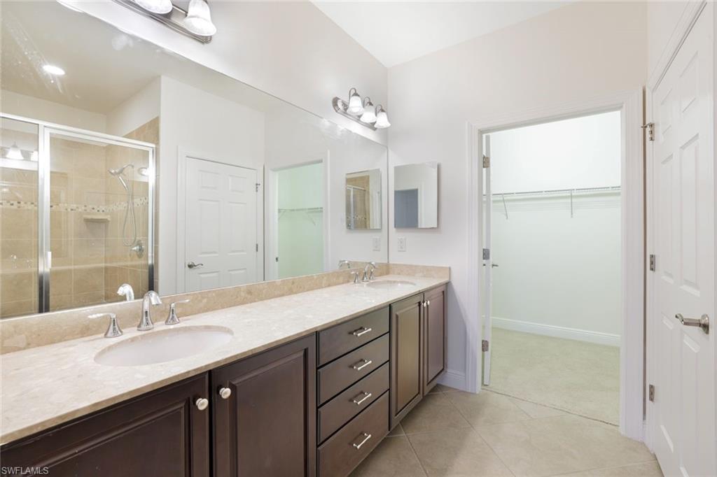 13366 Kent Street Naples, FL 34109 - Photo 12 of 23 Full bathroom with a shower stall, double vanity, light tile patterned flooring, and a spacious closet