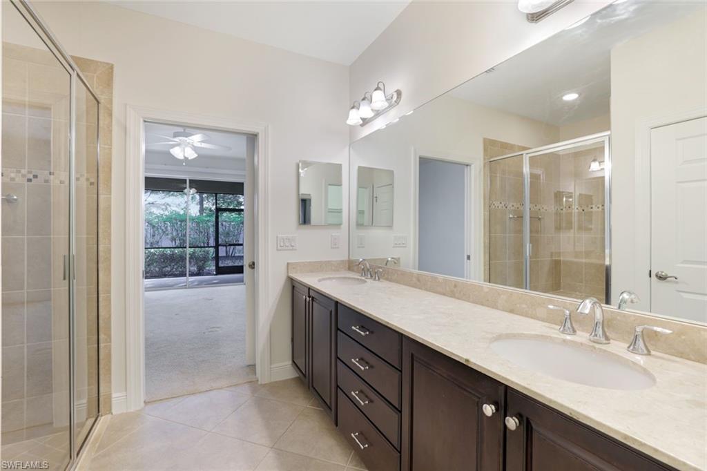 13366 Kent Street Naples, FL 34109 - Photo 13 of 23 Full bath with light tile patterned floors, double vanity, a shower stall, and light colored carpet