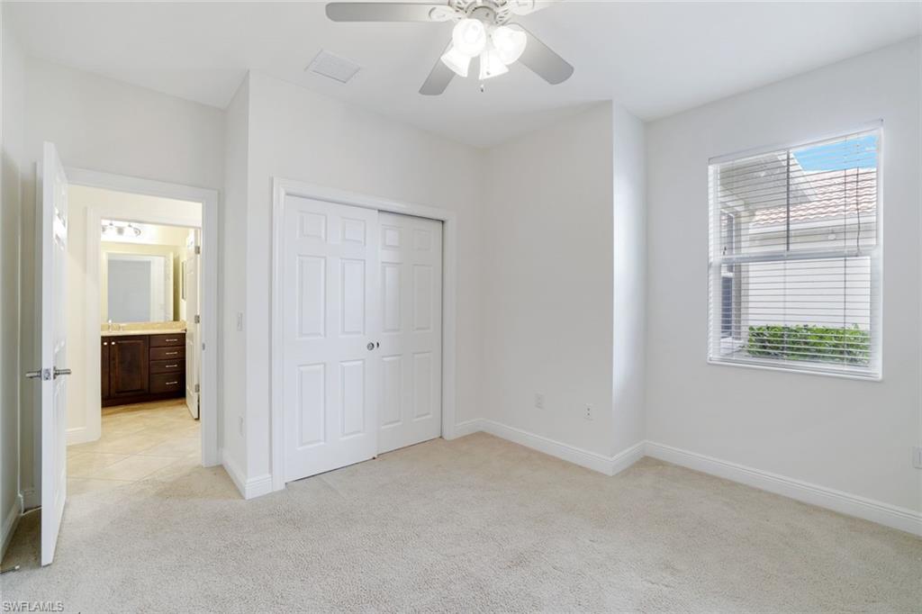 13366 Kent Street Naples, FL 34109 - Photo 14 of 23 Unfurnished bedroom with light carpet, a closet, ceiling fan, and connected bathroom
