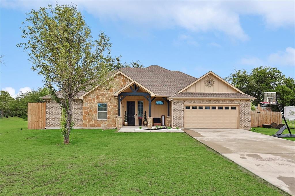 342 West Huffman Street Krum, TX 76249 - Photo 2 of 25 a front view of a house with a yard and garage