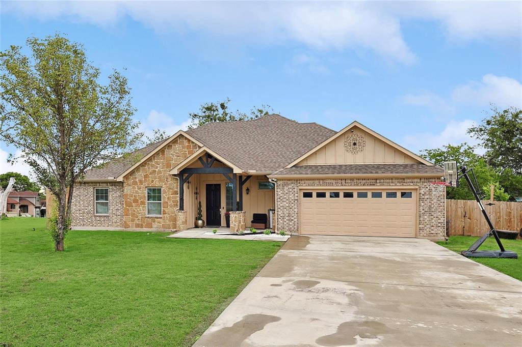 342 West Huffman Street Krum, TX 76249 - Photo 3 of 25 a front view of a house with a yard and garage