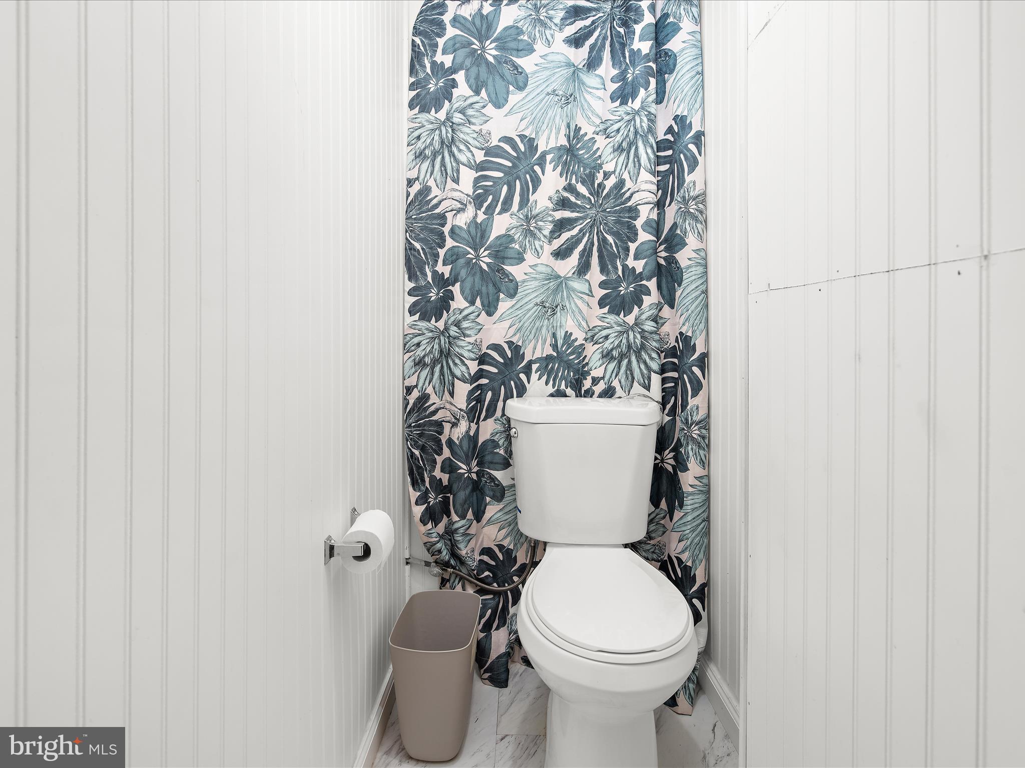 7851 Kentley Road Baltimore, MD 21222 - Photo 23 of 58 a white toilet sitting next to a shower curtain